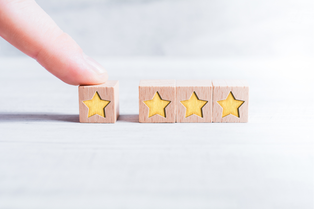Photo of 4 wooden blocks each with a carved star, 3 blocks side by side with a finger pushing the 4th block. To accompany the post: How to Use Survey Results to Drive Quality, Compliance and Connection